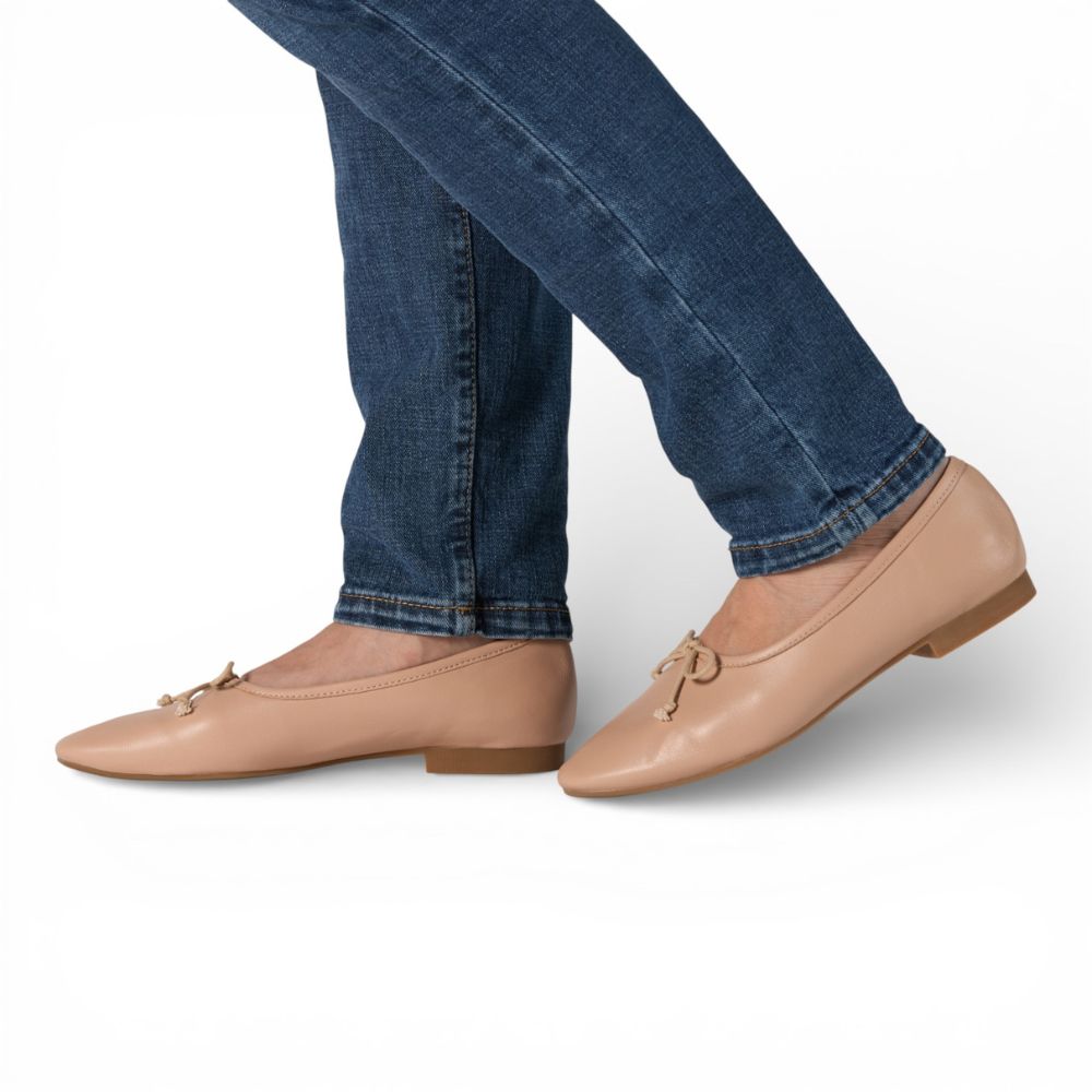 Roma Nude Leather Elegant Flat worn with blue jeans on a white background