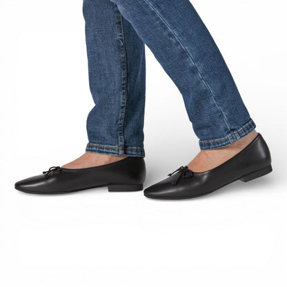 Roma Black Leather Elegant Flat worn with blue jeans on a white background