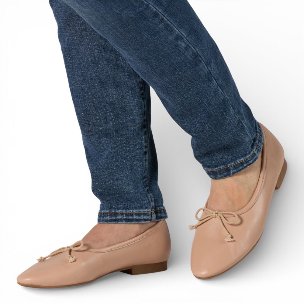 Roma Nude Leather Elegant Flat worn with blue jeans on a white background