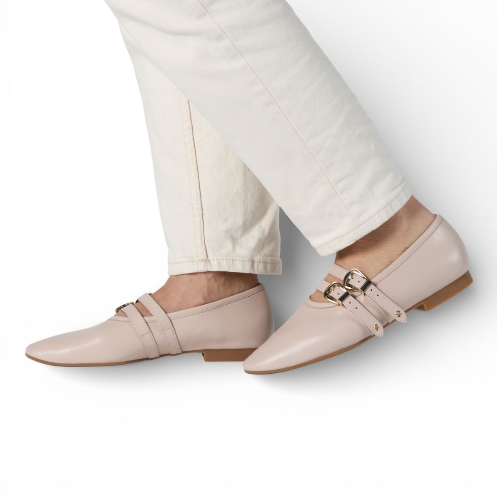 Dover Bone Leather Flat with Double Strap Detail worn with white pants on a light gray background