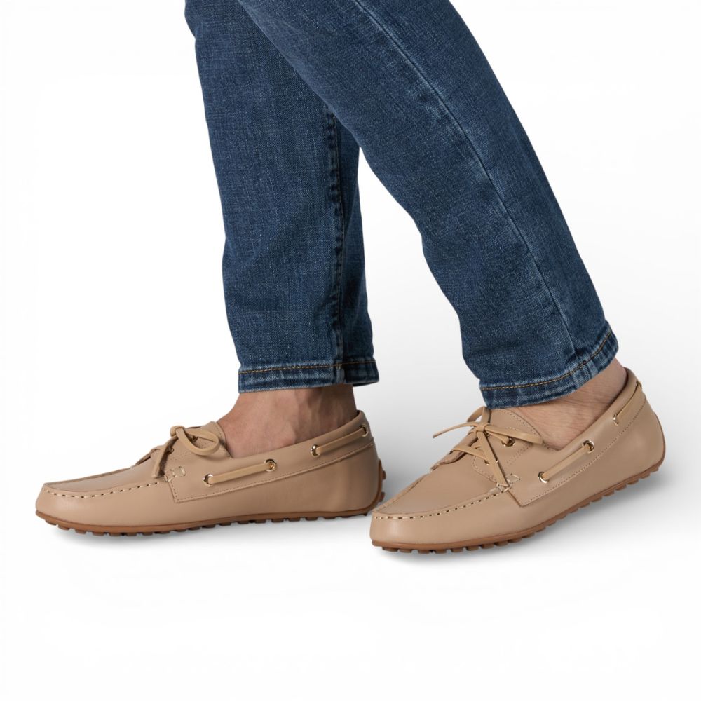 Sevilla Beige Leather Boat Moccasins worn with blue jeans on a white background