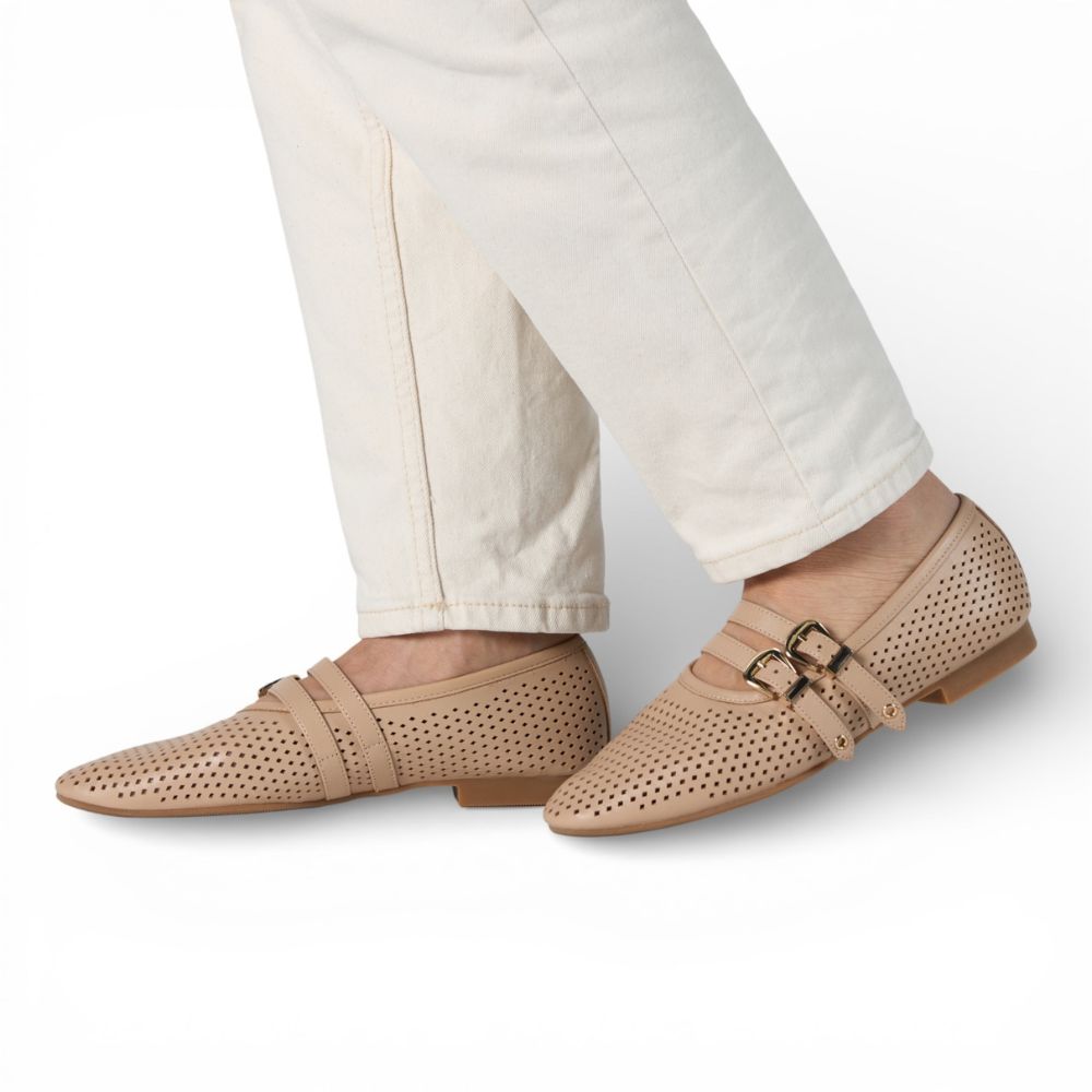 Dover Powder Perforated Leather Flat with Double Strap Detail worn with white pants on a light gray background