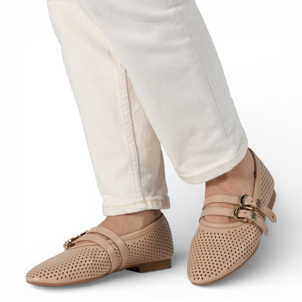 Dover Powder Perforated Leather Flat with Double Strap Detail with white pants on a light gray background